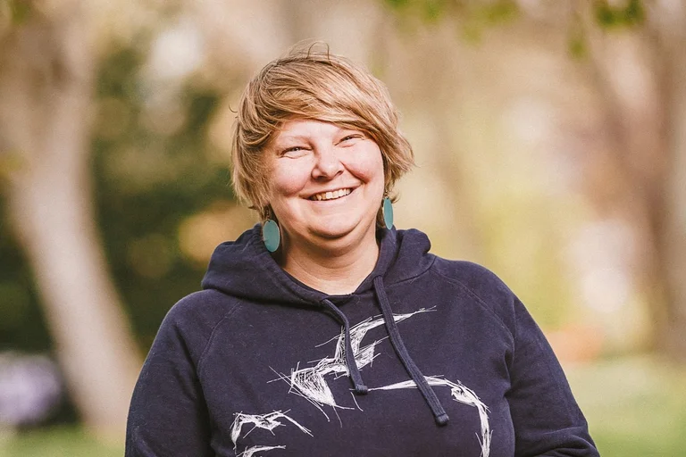 Frau lacht freundlich in die Kamera.