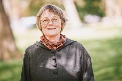 Frau in einem grünen Park lächelt in die Kamera. - Copyright: Guido Kollmeier