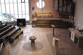 Blick von der Empore in den Innenraum mit Altar, Taufbecken und Orgel
