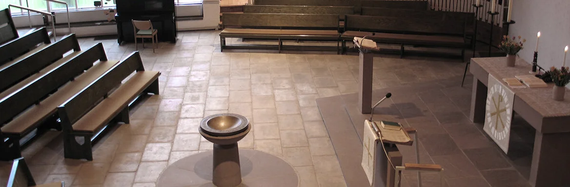 Blick von der Empore in den Innenraum mit Altar, Taufbecken und Orgel